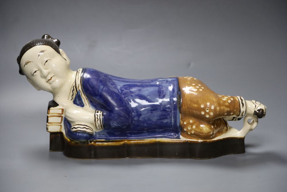 A Chinese porcelain pottery figural pillow, 42cm wide with related Hong Kong certificate